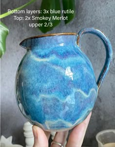 a hand holding a blue and white pitcher with the words bottom layers 3x blue ruttle top 2x smokey merlot upper 2 /