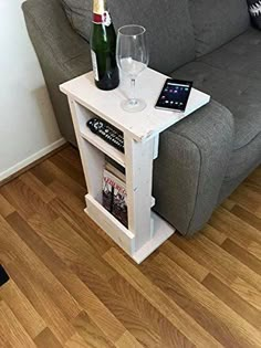 a couch and table with a bottle of wine on it in front of a sofa