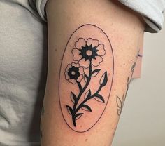 a woman with a tattoo on her arm has a flower in an oval frame and leaves