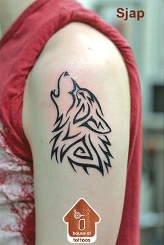 a woman with a tattoo on her arm that has a wolf head in the middle