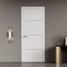 a white door in a gray room with a gold table and vase on the floor