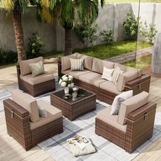 an outdoor living room with wicker furniture and palm trees