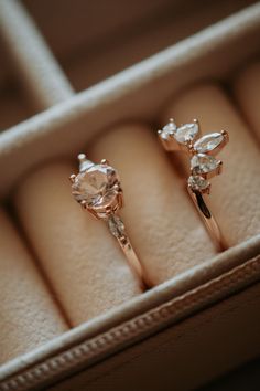 two engagement rings sitting in a box