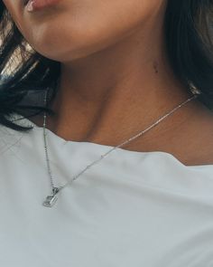 Brighten up everyday with the Cassia Pendant Necklace! A shining CZ stone in a simple pendant adds a touch of sparkle to any outfit. This chic accessory is sure to bring some shine to your day. Materials: 14K gold ﻿or﻿﻿ rhodium plated brass, cubic zirconia Features: Measures 16" with 2" extender, 1mm chain, 2mm beads, 0.6" pendant, 4.5mm CZ stone, Lead & Nickel free, lobster clasp 2mm Beads, Square Pendant Necklace, Simple Pendant, Ear Stack, Square Pendant, Pearl Earrings Dangle, Chic Accessories, Sterling Silver Hoops, Gold Pendant Necklace