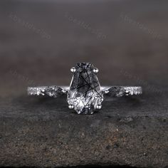 a close up view of a diamond ring on top of a stone slab with water droplets