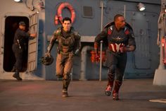 captain america the winter soldier is running with another man in front of him on a ship