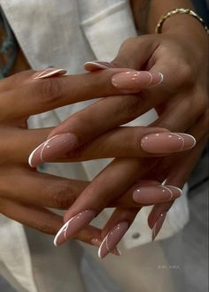 two hands holding each other with white and pink manies on their nails, one is holding the other's hand