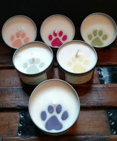 six cups with different colored paw prints on them and one is filled with white liquid