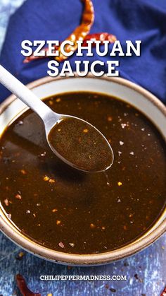 a spoon full of sauce sitting on top of a blue cloth with the words, sezechuan sauce