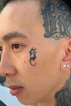 a man with a tattoo on his head and behind his ear looking at the camera