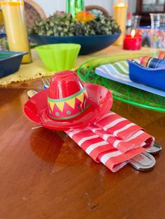 a red hat sitting on top of a table next to utensils and plates