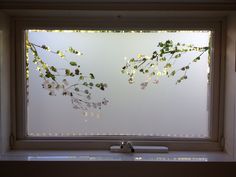 a window with some flowers on it and a pen in front of the windowsill