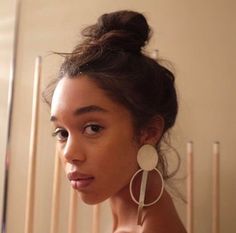 a woman wearing large white hoop earrings