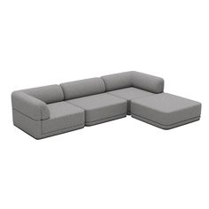 a large gray sectional couch sitting on top of a white floor