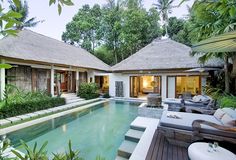 an outdoor swimming pool surrounded by greenery