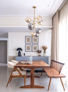 a dining room table with four chairs and a chandelier hanging from the ceiling