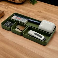 a wooden table topped with two trays filled with money and other office supplies on top of it