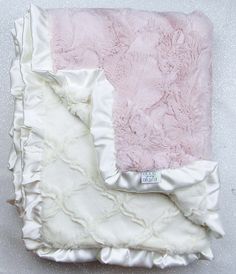 a pink and white blanket with ruffled edges