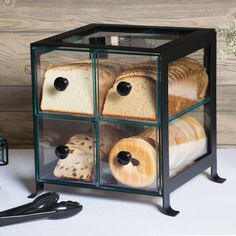 an assortment of breads and pastries in a glass box