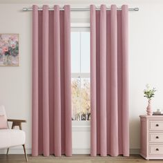 a living room with pink curtains and a white chair