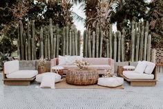 a living room with couches, chairs and tables in front of bamboo fenced trees