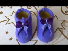 a pair of purple baby shoes sitting on top of a table