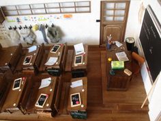 an overhead view of desks and chairs in a room with a chalkboard on the wall