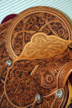 an intricately carved saddle sits on top of a blanket