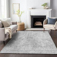 a living room with white furniture and a gray rug in front of a fire place