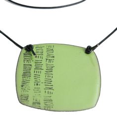 a green necklace with black cord and an inscription on it that reads,'i am not