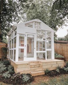 a small white house sitting on top of a wooden platform