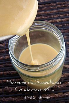 homemade sweetened condensed milk being poured into a jar