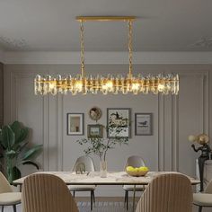 a dining room table with four chairs and a chandelier hanging from the ceiling