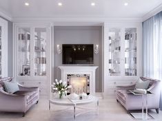 a living room filled with furniture and a flat screen tv mounted on the wall above a fire place