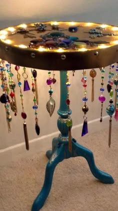 a blue table with lots of beads hanging from it's sides and lights on the top