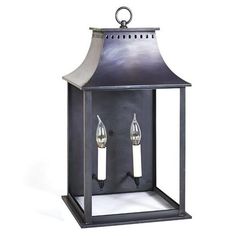 a metal lantern with two candles on the front and one light on the back, against a white background