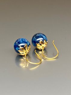 Beautiful vibrant and high-grade kyanite globe earrings. The 12 mm kyanite globes have a gorgeous deep vibrant blue color. The globes attached to beautiful 14K gold-filled flower caps as they dangle from the vermeil on sterling ear wires. These are elegant and perfect earrings to go with any outfit. A pair of fine gemstone essentials. *Ball size (diameter): 12 mm *Metal: vermeil on sterling *Earrings drop length (ear wires including the crystals): 25mm / 1 inch Solid gold, silver, and gemstones Handmade Round Lapis Lazuli Earrings, Blue Lapis Lazuli Earrings For Gift, Round Lapis Lazuli Gemstone Earrings, Blue Round Beads Spiritual Earrings, Blue Lapis Lazuli Earrings For Formal Occasions, Blue Spiritual Earrings With Round Beads, Royal Blue Lapis Lazuli Round Jewelry, Formal Blue Lapis Lazuli Earrings, Blue Spiritual Earrings For Gifts