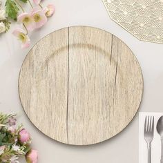 a wooden plate sitting on top of a table next to flowers and utensils