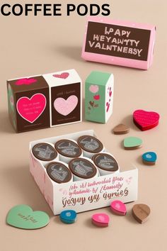 valentine's day coffee pods are in a box with hearts and candy on the table