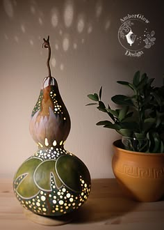 a potted plant sitting on top of a wooden table next to a ceramic vase