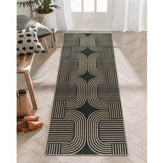 a black and white runner rug with an abstract design on the floor in front of a window