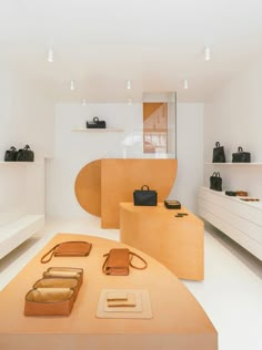 a room filled with lots of wooden furniture and bags on display in it's center