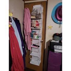 a closet with clothes and hats hanging on the wall next to a hat rack in front of a door