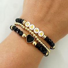 The Candace Stack is a beautiful and classy way to combine gold and black. Each bracelet comes with 6mm 18K plated gold beads, 6mm crystal Rondelle black beads, and 6mm gold plated spacer disk beads on 0.5 mm elastic. The gold plated black heart is 10mm.   Care tips for your stack and bracelets ~ Store and handle bracelets gently. Repeated stretching can weaken the elastic and shorten the life of your bracelets. ~ Avoid water and sweating while wearing bracelet. Thank you for shopping small! Black Bracelets With Letter Beads, Elegant Black Beaded Bracelets With Letter Beads, Elegant Black Bracelets With Letter Beads, Elegant Black Bracelet With Letter Beads, Swiftie Bracelets, Black And Gold Bracelet, Small Bead Bracelet, Bracelets Ideas, Bead Projects