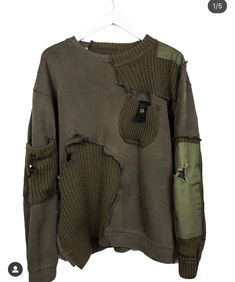 a green sweater with patches and buttons on the front, hanging from a clothes line