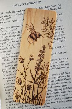 a wooden bookmark with a bee on it