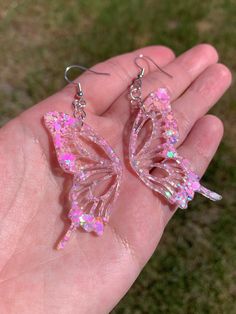 Each pair of earrings are handmade to order, therefore no two pairs are identical! However, I try to get as close as possible :) Hypoallergenic & nickel-free sterling silver plated fishhook earrings. Each butterfly wing is approximately 2 inches in length and are made with epoxy resin, iridescent pastel pink glitter, & holographic glitter ✨  These dangly sparkly resin butterfly earrings are perfect for any occasion! Color may vary slightly. Thanks for visiting my shop! 💕 Other color options are Pink Butterfly Earrings, Cute Butterfly-shaped Jewelry For Parties, Handmade Pink Butterfly Earrings, Whimsical Hypoallergenic Party Earrings, Cute Pink Glitter Earrings, Handmade Iridescent Dangle Earrings, Cute Pink Butterfly Earrings, Whimsical Iridescent Earrings With Ear Wire, Cute Resin Earrings For Party