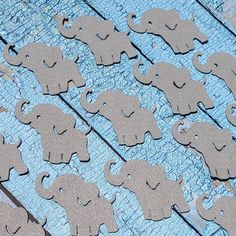 wooden cutouts of elephants on a blue tablecloth with wood grained boards in the background