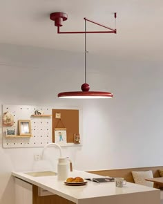 a kitchen with a white counter top next to a wall mounted light fixture above it