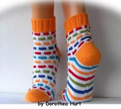 two pairs of socks with colorful stripes on them, one is orange and the other is white